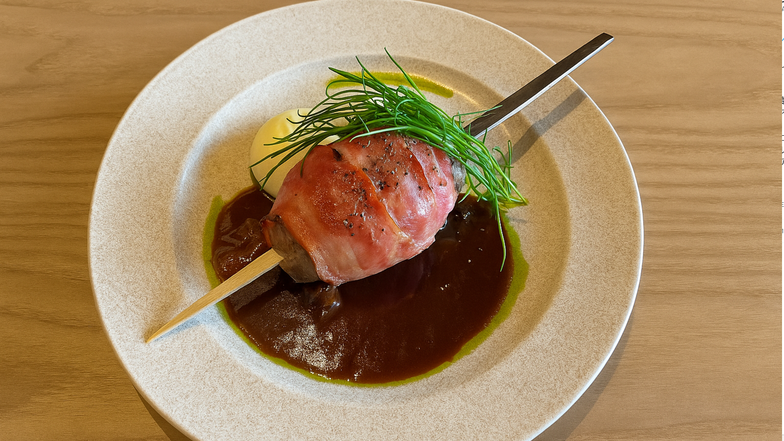 パノラマダイニングの名物メニュー、ジャングリアハンバーグ。ベーコンで包まれたハンバーグに濃厚ソースとマッシュポテトを添えた一皿。