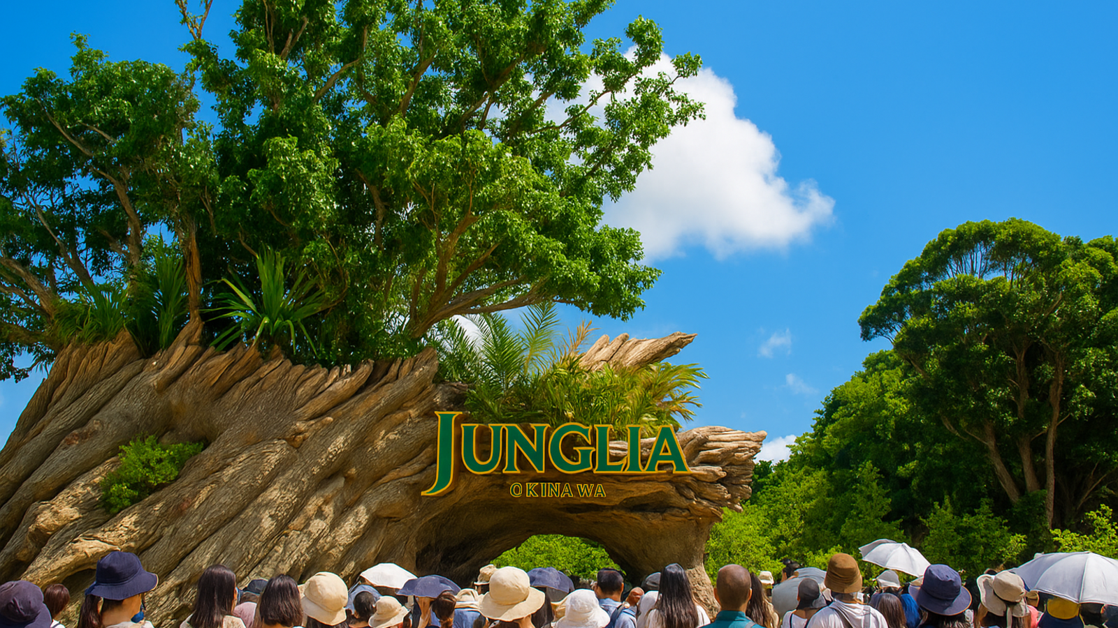 沖縄のテーマパーク「ジャングリア」の入口ゲート前に、多くの来場者が集まっている様子。大きな木と青空が背景に広がる。