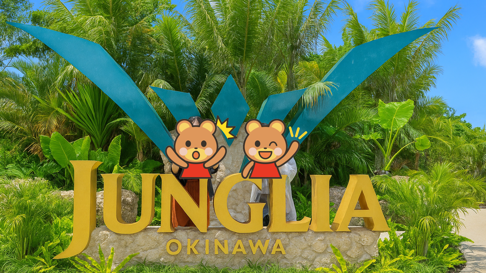 ジャングリア沖縄の入口にある大型モニュメント。緑豊かな南国の植物に囲まれた黄色い「JUNGLIA OKINAWA」のロゴ